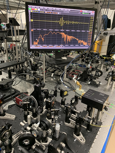 NIST’s tabletop frequency comb apparatus (foreground) can quickly identify molecules based on their absorption of infrared light. Credit: NIST