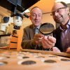 Photo of Kenneth Sheedy and Gil Davis examining ancient coins.